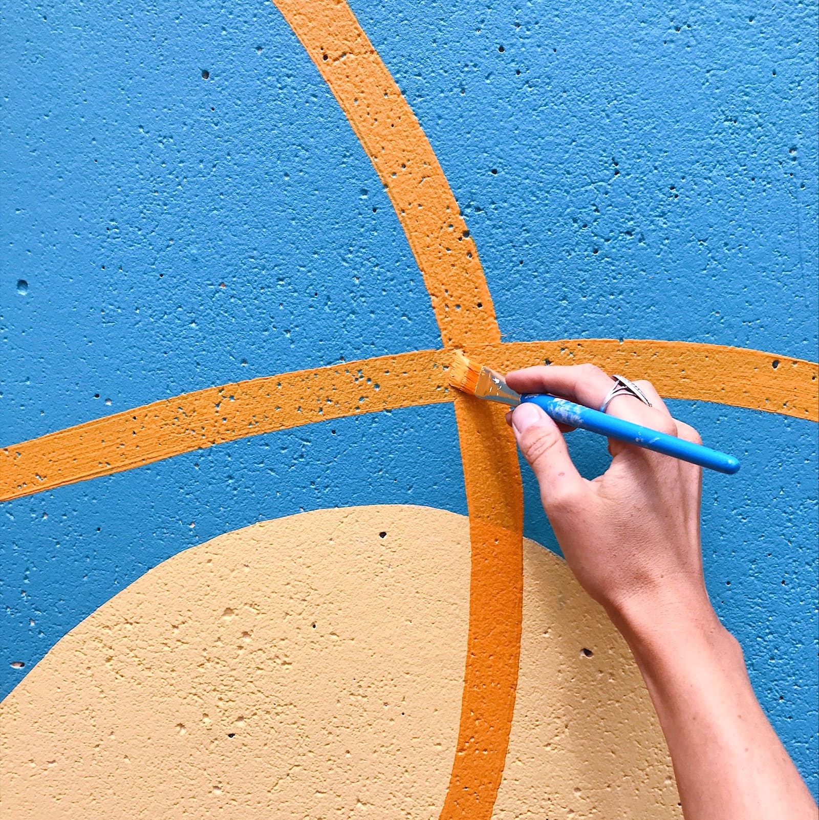 Artist hand-painting a mural detail